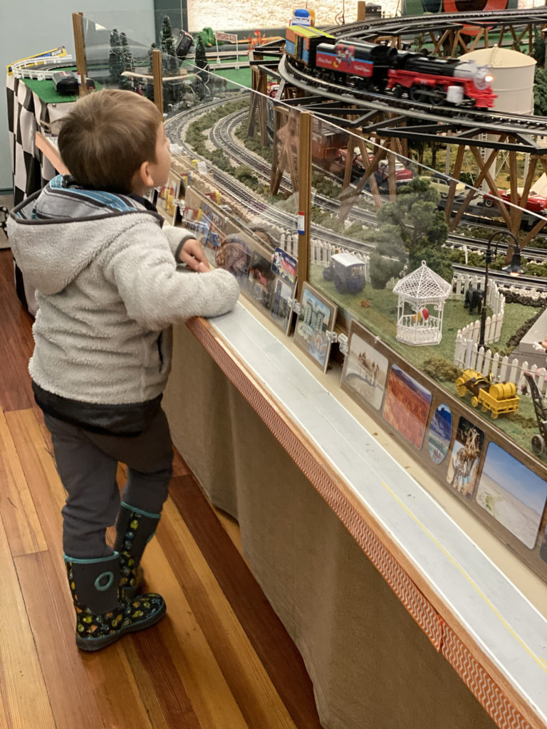Little boy at Marshall County Historical Museum in the Train Room watching the trains intently. One of the best family activities for Culver and South Bend kids. 