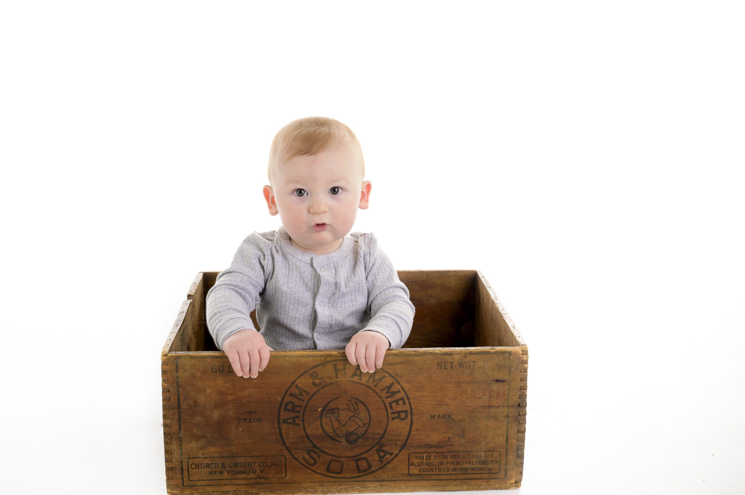 Baby sitting in wooden box.