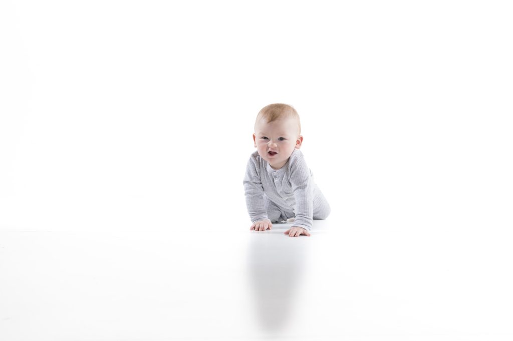 Baby crawling on white background. 