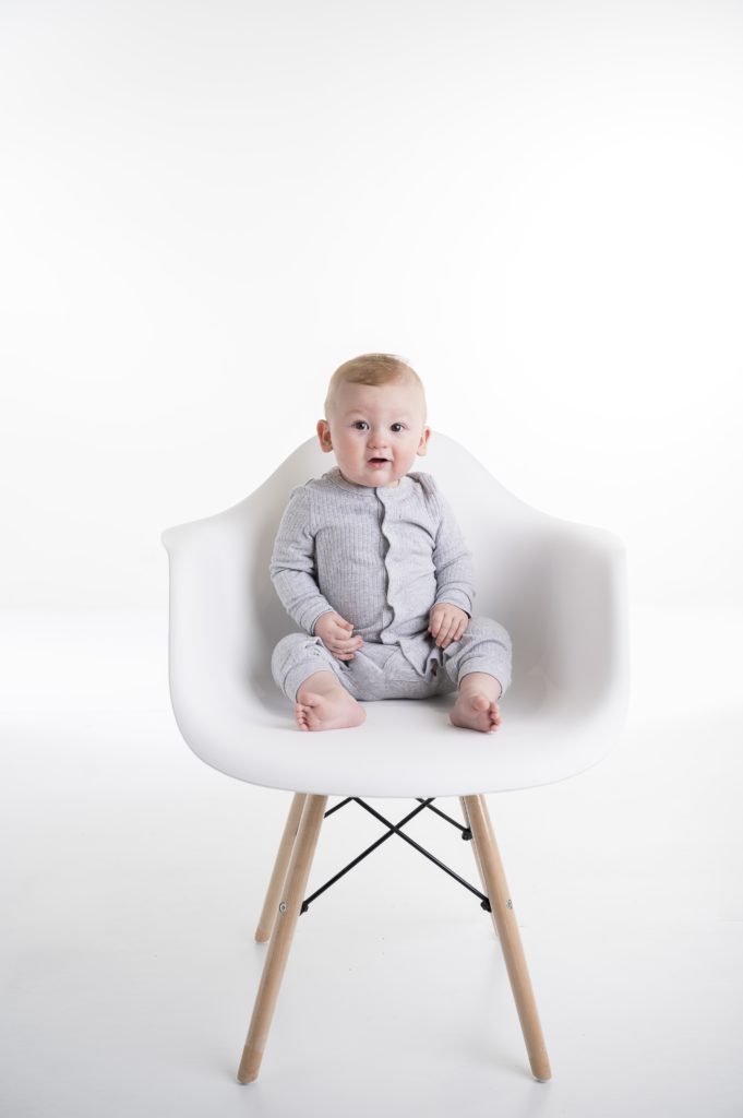 Baby sitting in a modern mid-century modern chair. 