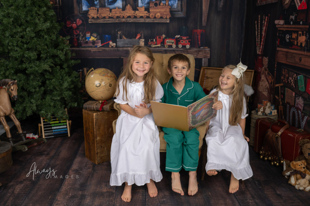 Children cuddled up and reading The Night Before Christmas in Santa's Workshop.