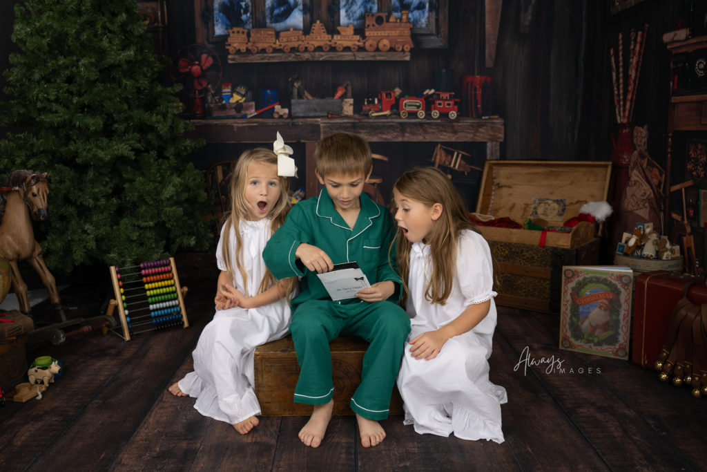 Children wearing pajamas and looking at a letter from Santa with surprised faces.