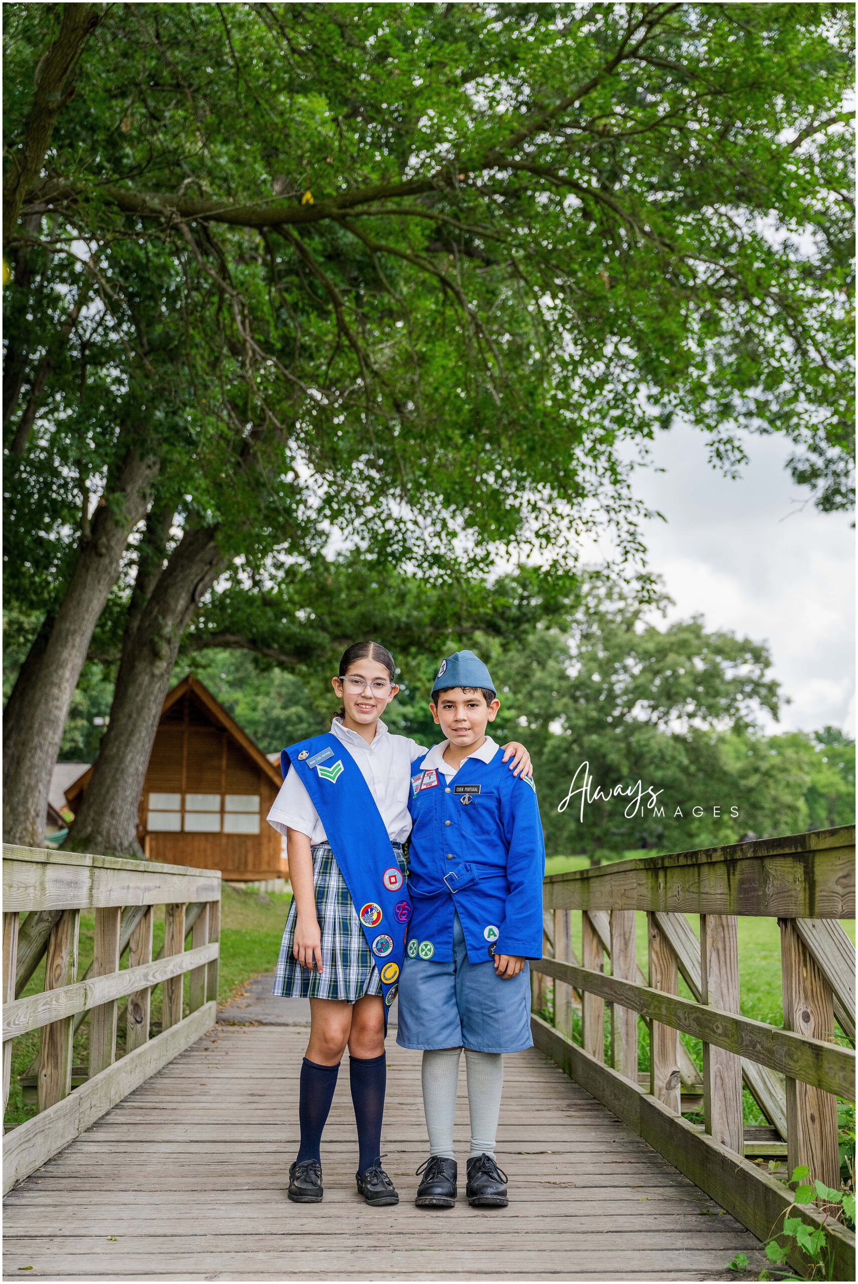 Siblings standing on Cardinal bridge together dressed in Culver Woodcraft uniforms.