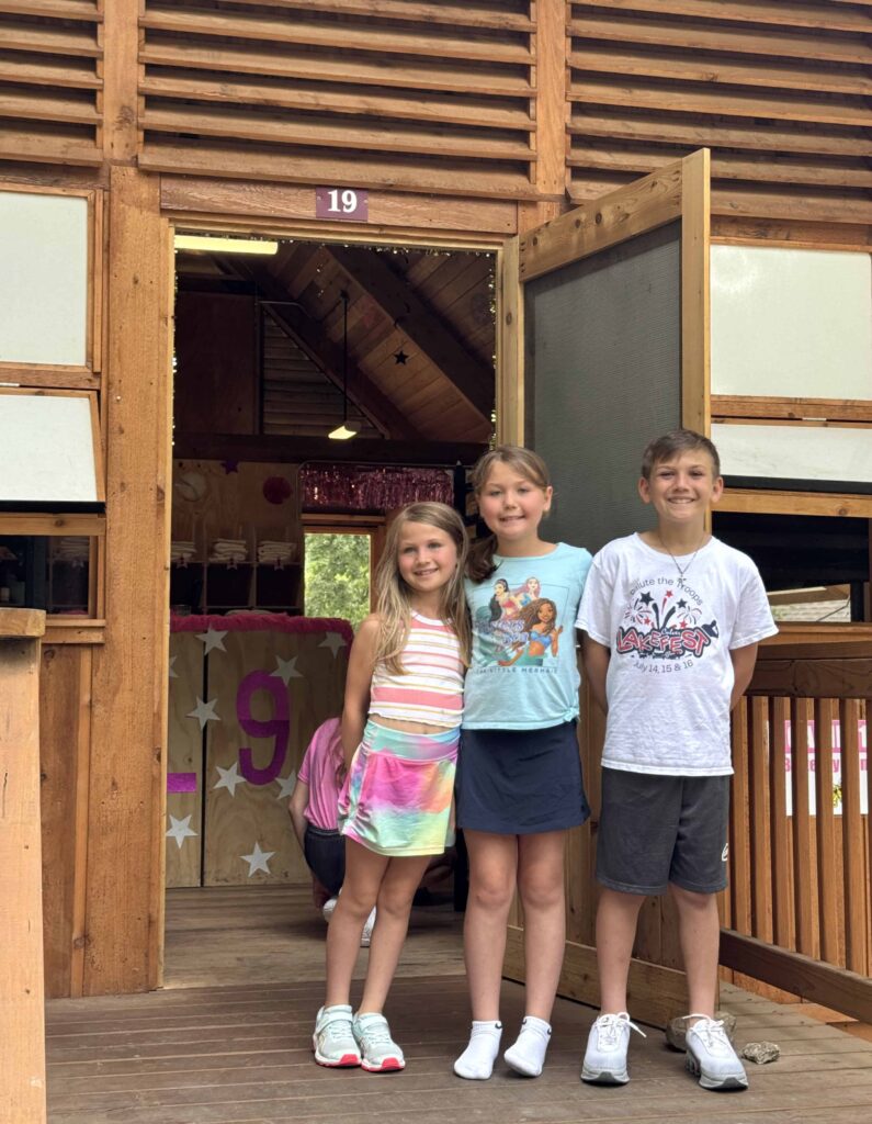 Siblings standing together on Culver Academies Woodcraft camp cabin steps at drop off for camp.